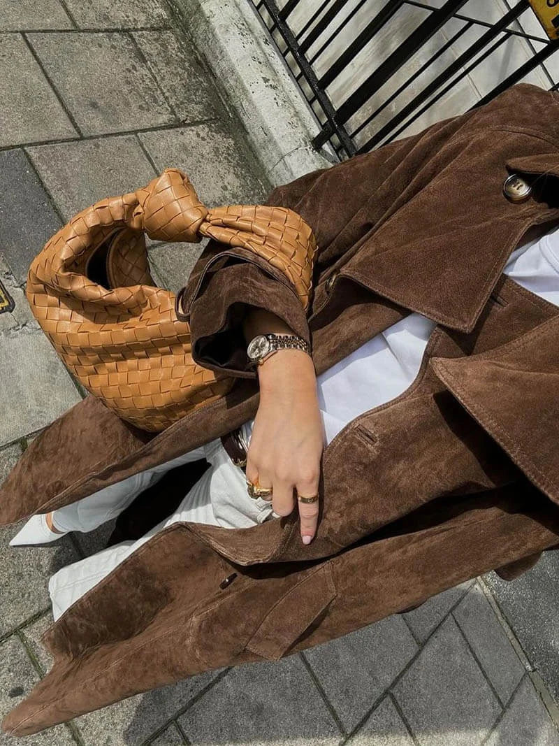 Women's brown trench coat made of durable fabric, featuring a belted waist and classic lapels for a timeless look.