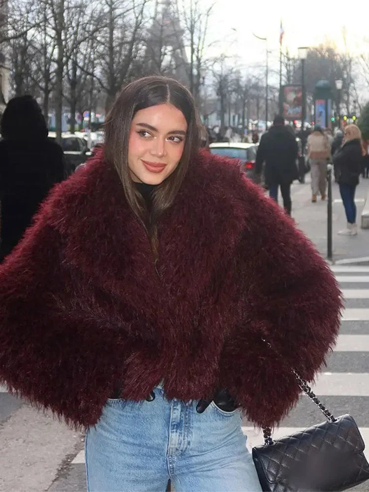 Women's burgundy faux fur coat featuring an oversized collar and soft, cozy material for warmth and style in colder weather.