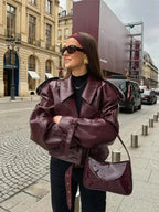 Women's burgundy short belted trench coat made from cotton blend; features classic design and stylish waist belt for a…