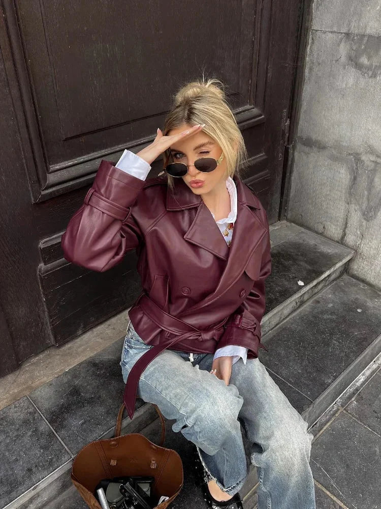 Women's burgundy short belted trench coat made of lightweight fabric, featuring a classic double-breasted design and stylish…