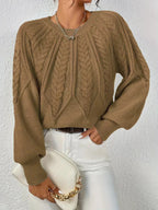 Warm women's cable-knit sweater featuring a textured pattern and cozy fabric, perfect for casual outings in cooler weather.