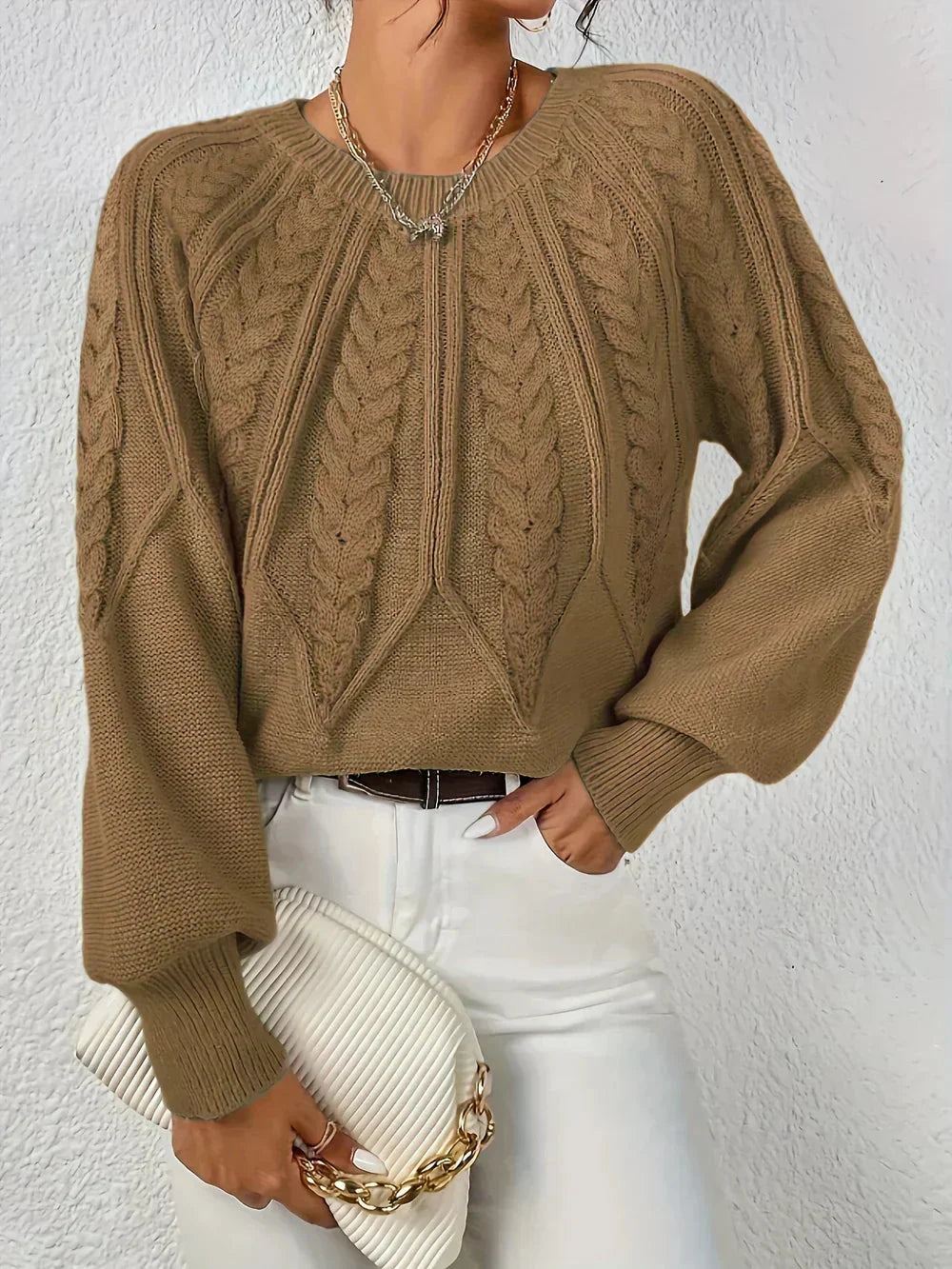 Warm women's cable-knit sweater featuring a textured pattern and cozy fabric, perfect for casual outings in cooler weather.