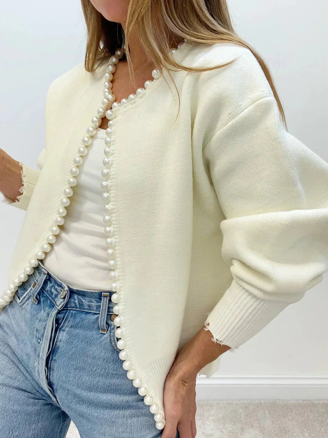 Women's open front cardigan featuring pearl trim, crafted from soft knit fabric for comfort and style. Casual and versatile.