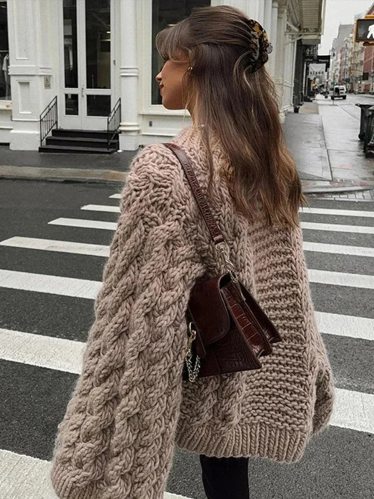 Women's oversized chunky knit sweater with wide sleeves, featuring a cozy material and a relaxed fit for comfort.