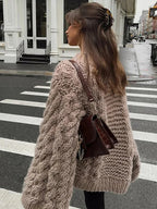 Women's oversized chunky knit sweater with wide sleeves, featuring a cozy material and a relaxed fit for comfort.