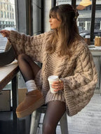 Women's oversized sweater made of chunky knit fabric, featuring wide sleeves and a cozy, relaxed fit for comfort.