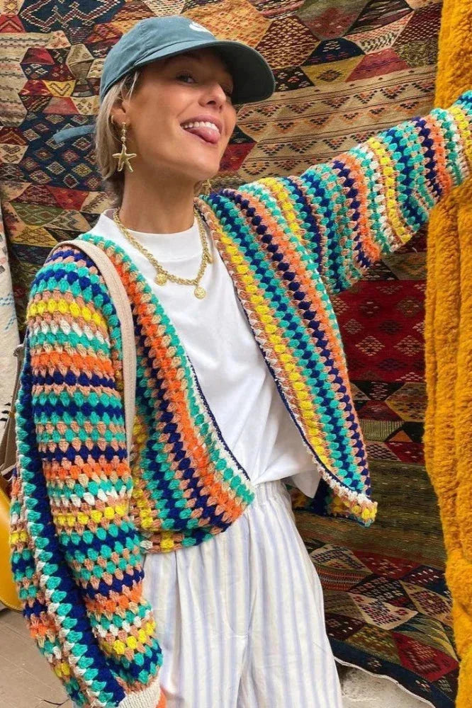 Women's knitted cardigan featuring vibrant rainbow stripes, made from soft, cozy yarn for warmth and comfort.