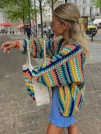 Women's colorful knitted cardigan featuring rainbow stripes, made from soft acrylic blend, showcasing an open front design.