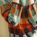 Women's turtleneck sweater featuring a colorful patchwork design made from soft yarn for a cozy fit.
