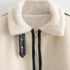 Women’s cozy cream teddy jacket with zip-up front, featuring side pockets and soft fabric for warmth and comfort.
