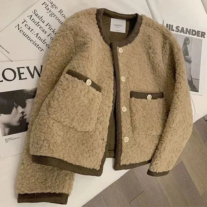 Women's fleece jacket with stylish trim, featuring soft fabric, a zippered front, and two side pockets for everyday wear.