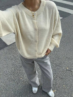 Women's knitted cardigan featuring a button front, crafted from soft yarn for comfort and warmth in a relaxed fit.