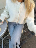 Women's cozy knitted cardigan featuring a button front, crafted from soft yarn for warmth and comfort in everyday wear.