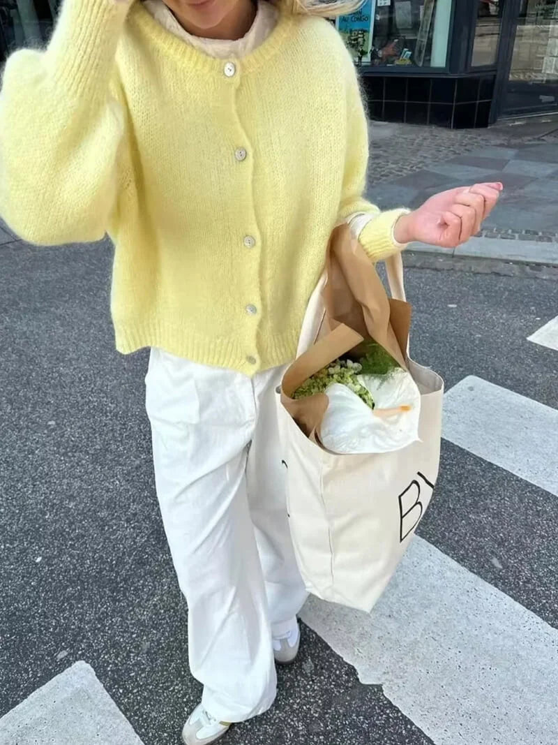 Women's cozy knitted cardigan with button front, crafted from soft yarn, featuring a relaxed fit and classic ribbed cuffs.