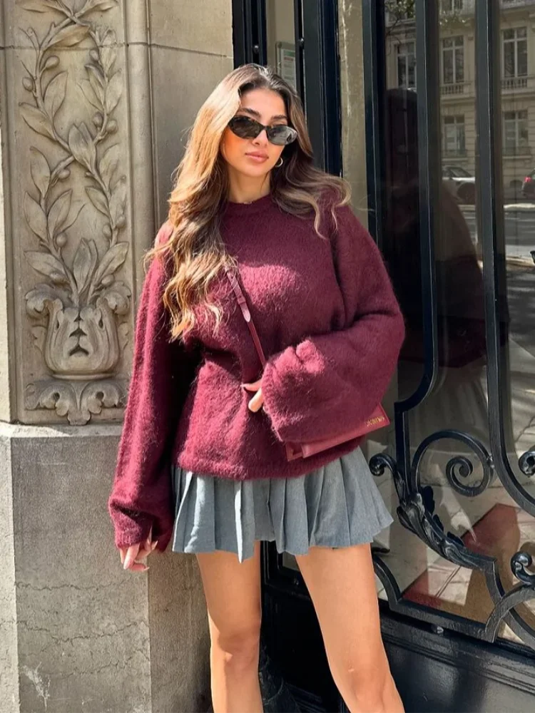 Women's cozy oversized sweater with round neck, made from soft knit fabric, features a relaxed fit and ribbed cuffs.
