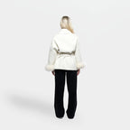Women's cream jacket with tie belt and fur cuffs, made from soft fabric, featuring a stylish wrap design and warm accents.