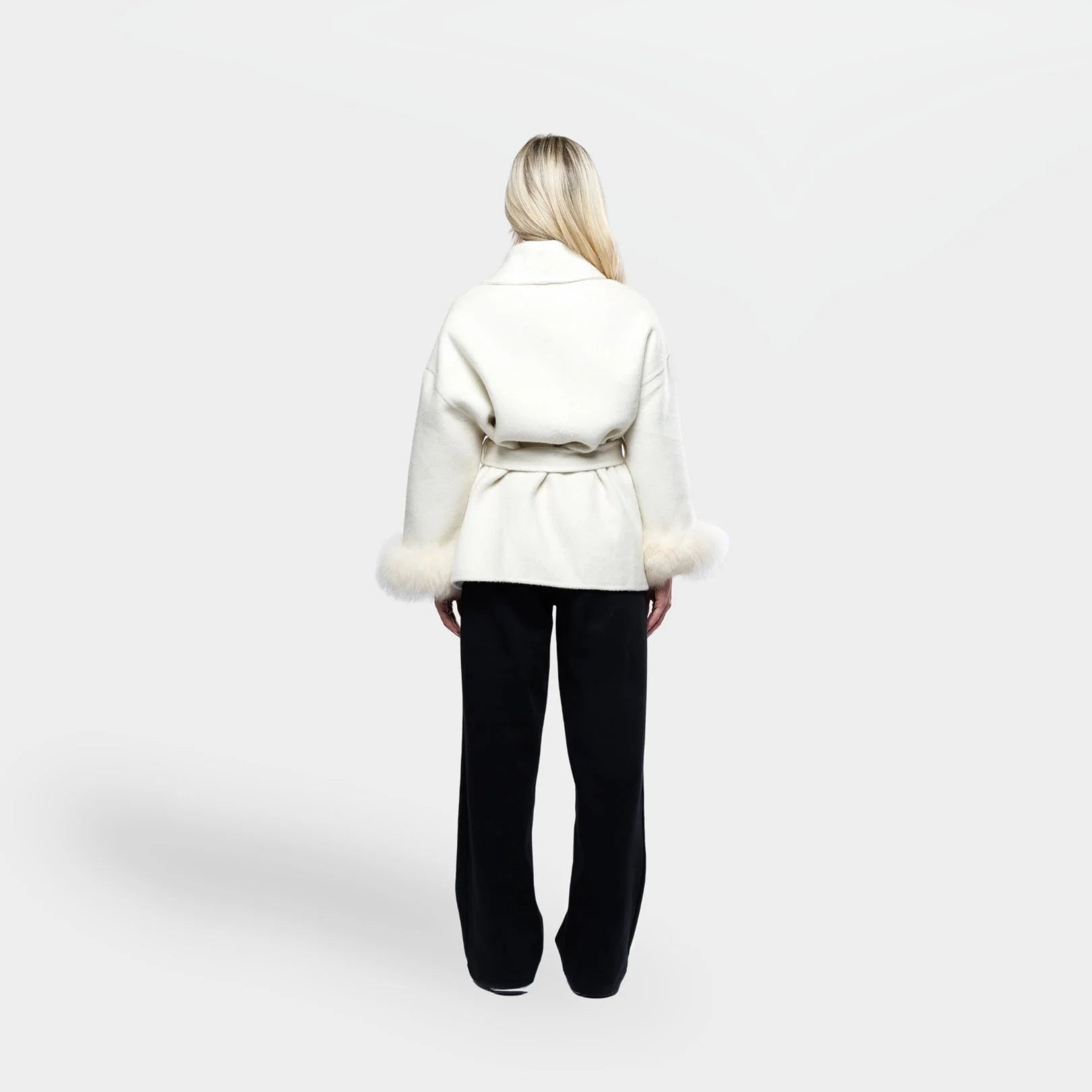 Women's cream jacket with tie belt and fur cuffs, made from soft fabric, featuring a stylish wrap design and warm accents.