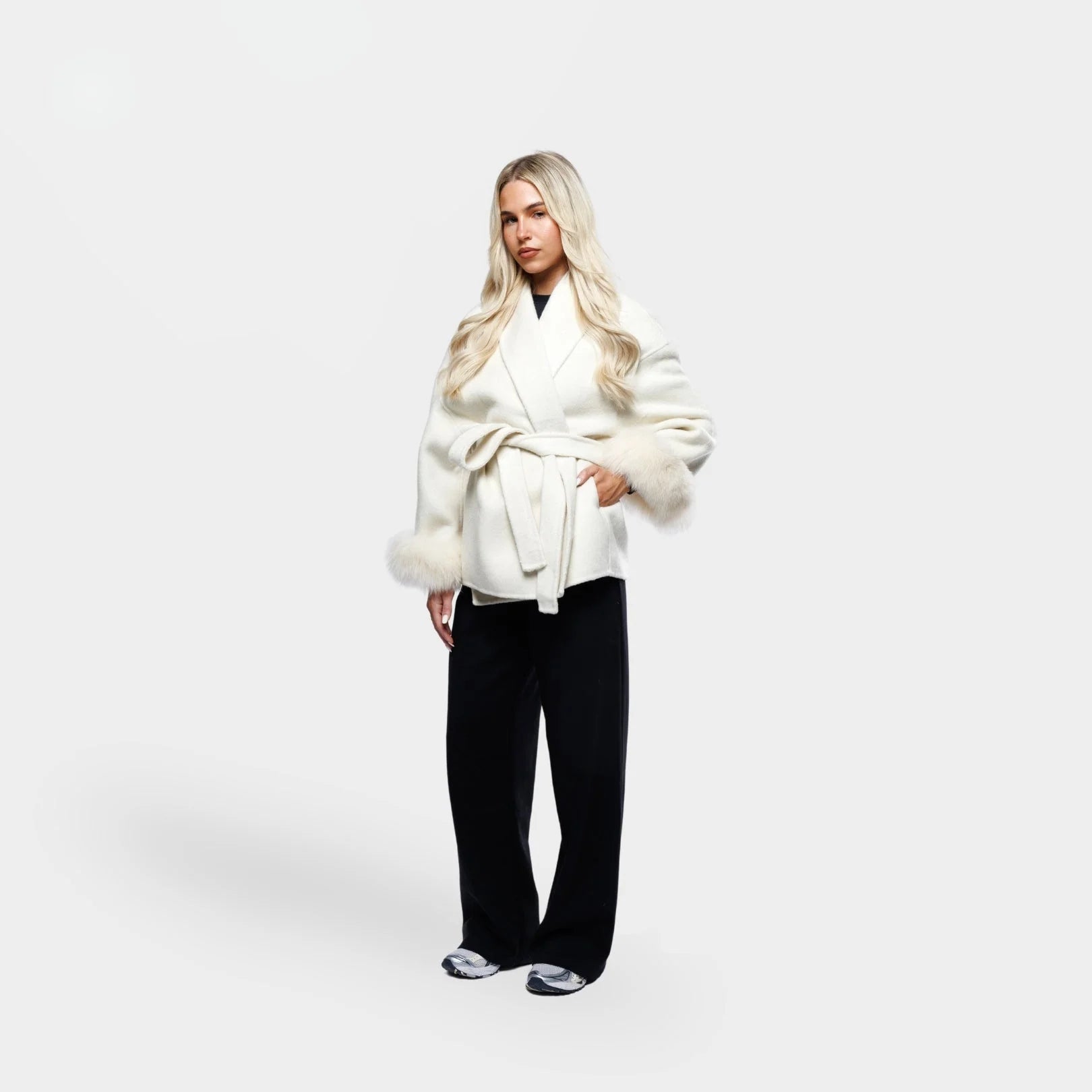 Women's cream jacket with tie belt, featuring soft fur cuffs and a comfortable fabric for a stylish, layered look.