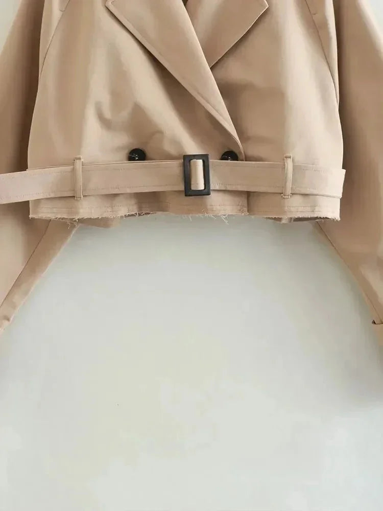 Beige cropped trench coat for women, featuring long sleeves and a classic belted design, made from lightweight fabric.
