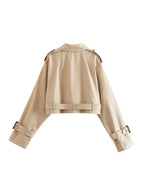 Women's cropped beige trench coat made of lightweight fabric, featuring long sleeves and classic double-breasted design.