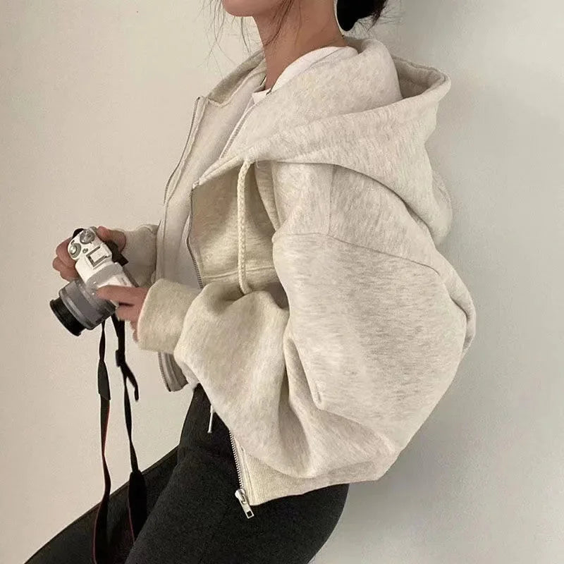 Women’s cropped hooded sweatshirt in soft cotton with zip-up closure and drawstring hood, ideal for casual layering.