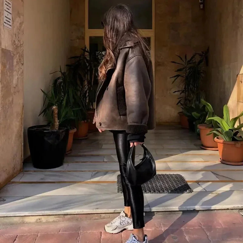Women's dark brown faux shearling coat featuring wide lapels and a soft, cozy texture for stylish warmth in cooler weather.