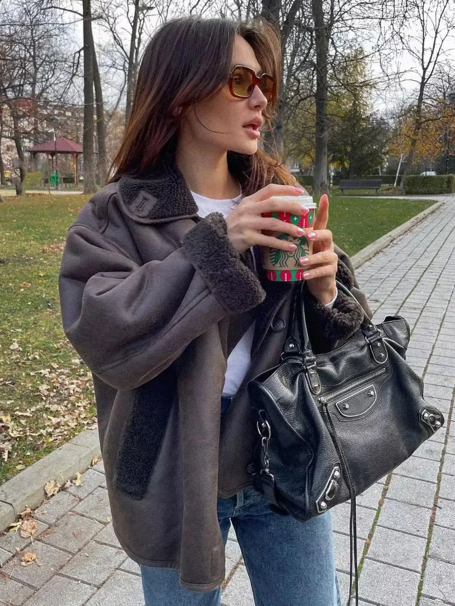 Women's dark brown faux shearling coat featuring wide lapels and a soft, textured finish for warmth and style.