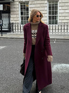 Women's double-breasted burgundy overcoat with a lapel collar, crafted from warm wool blend suitable for chilly weather.