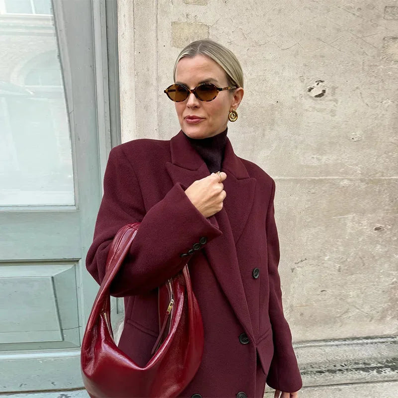 Women's double-breasted burgundy overcoat with a lapel collar, featuring a tailored fit and soft wool blend fabric.