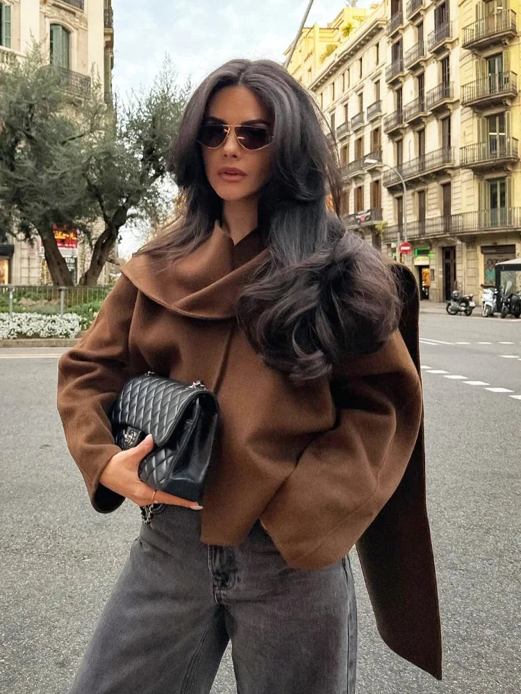 Women's winter coat with a draped collar, made from soft fabric, featuring a tailored silhouette and stylish button detail.