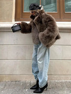 Brown women's faux fur coat featuring long sleeves and a textured finish, perfect for cozy, stylish warmth in cooler weather.