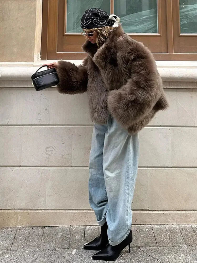 Brown women's faux fur coat featuring long sleeves and a textured finish, perfect for cozy, stylish warmth in cooler weather.