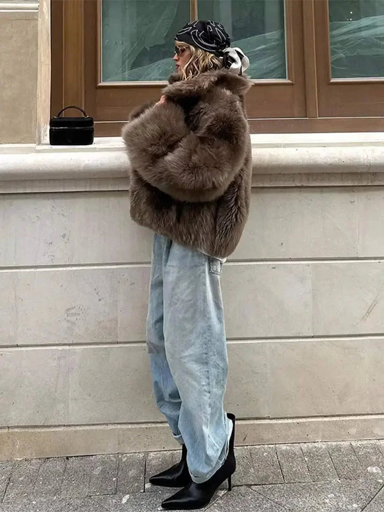 Brown women's faux fur coat featuring long sleeves and a soft, textured finish, perfect for warmth and style in colder…