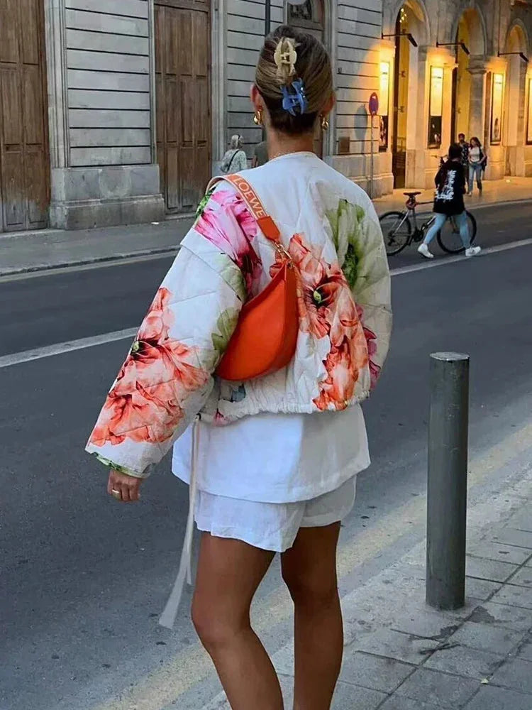 Women's floral bomber jacket made from lightweight fabric, featuring drawstring details and a vibrant floral pattern.