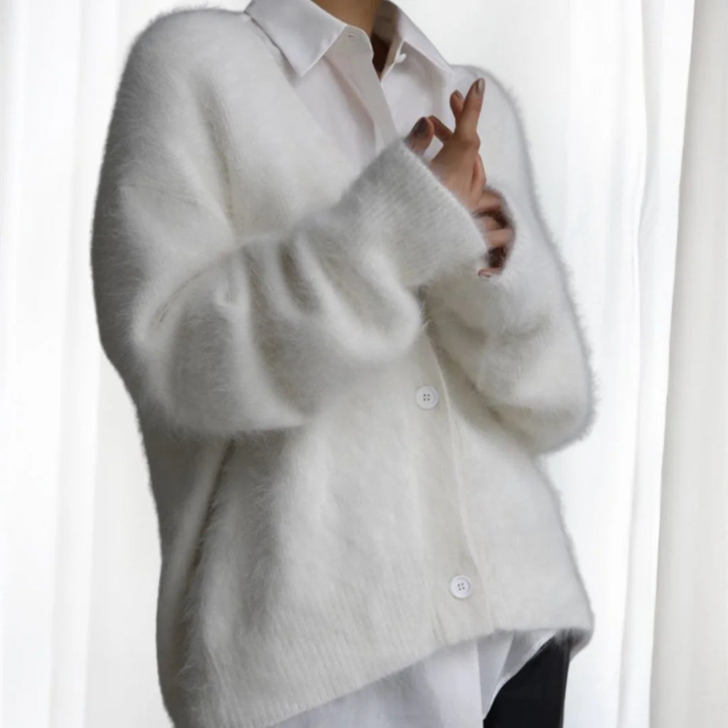 Women's oversized cardigan made of soft, fuzzy fabric with button front and spacious pockets for cozy layering.
