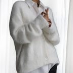 Women's oversized cardigan made of soft, fuzzy fabric with button front and spacious pockets for cozy layering.