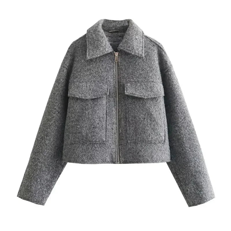 Women's grey cropped jacket with long sleeves, featuring a soft fabric and stylish silhouette for versatile layering.