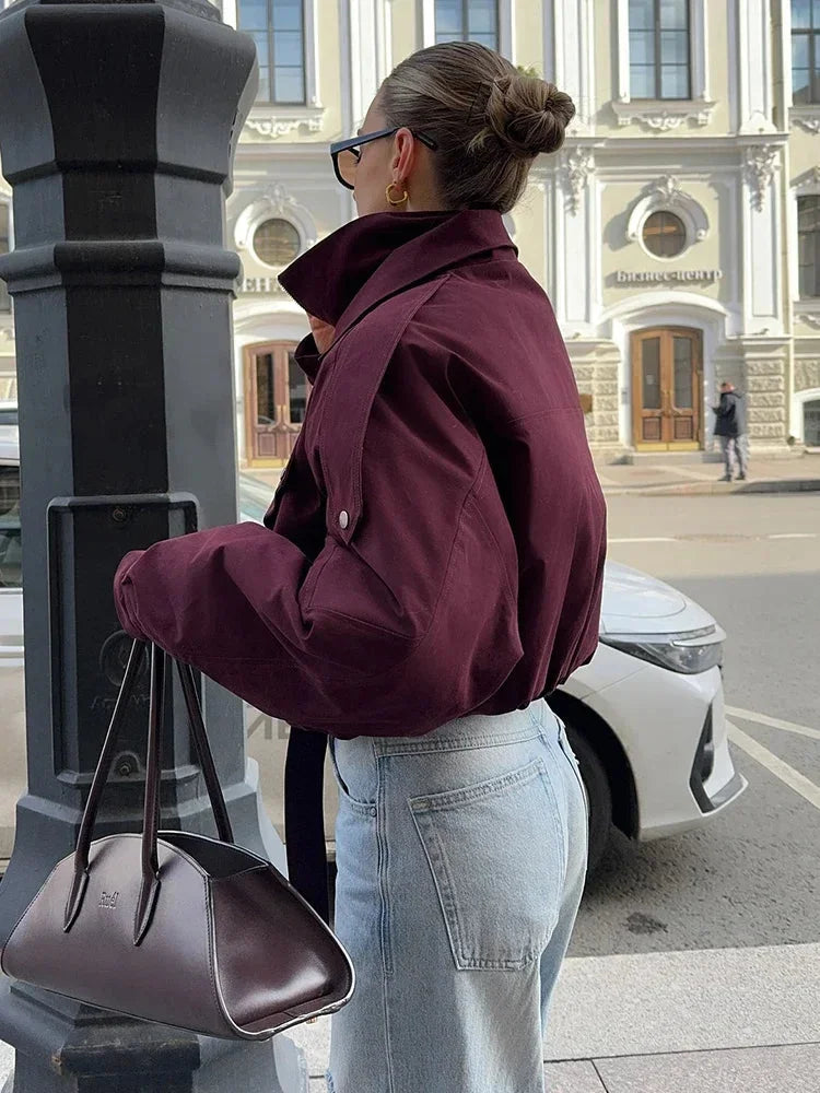 Women's high collar bomber jacket in durable fabric, featuring side pockets and a stylish, fitted design for a modern look.