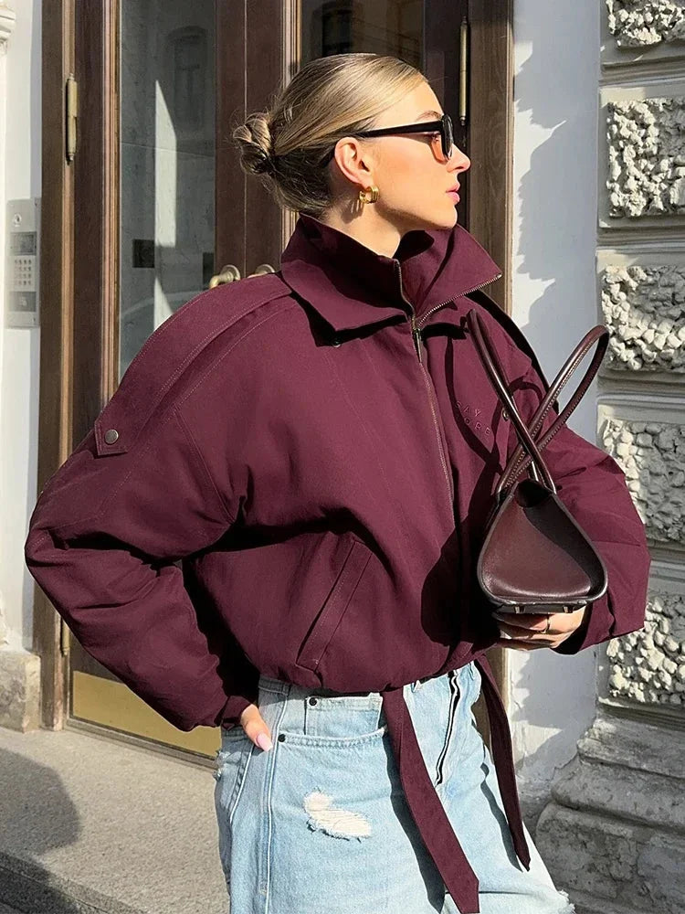 Women's high collar bomber jacket made of durable fabric, featuring practical pockets and a stylish, sporty design.