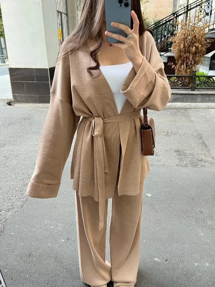 Women's knitted cardigan and pants set featuring a belted design in soft, breathable fabric for comfort and style.