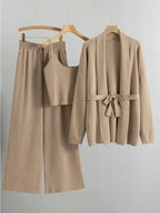 Women's knitted cardigan and pants set in soft fabric, featuring a belted design for a flattering silhouette.