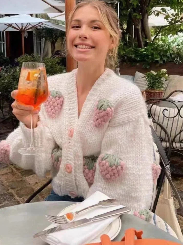 Women's knitted cardigan featuring a playful strawberry pattern, made from soft, breathable yarn for comfort and style.