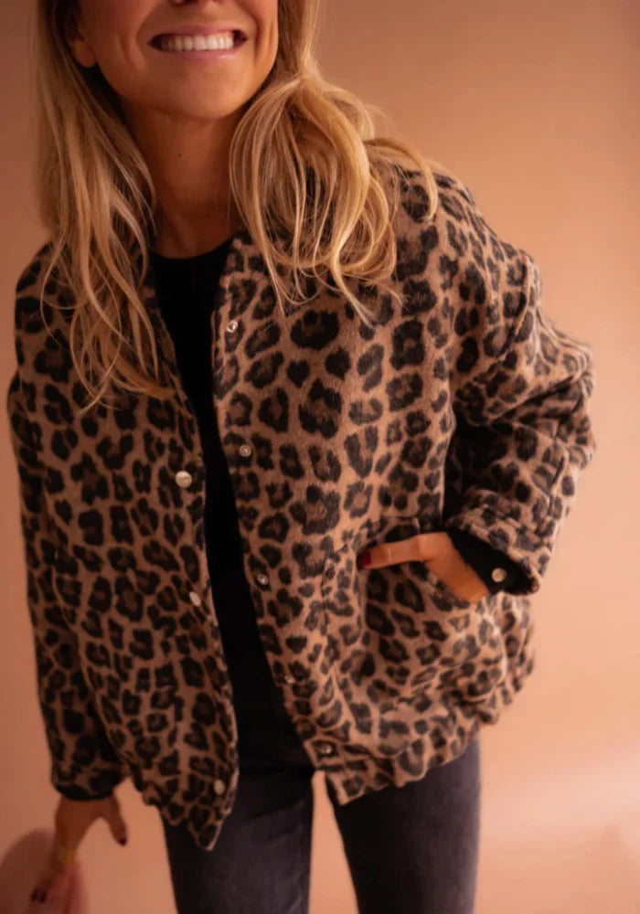Women's leopard print button-up jacket made of soft fabric with a classic collar and two front pockets for added…
