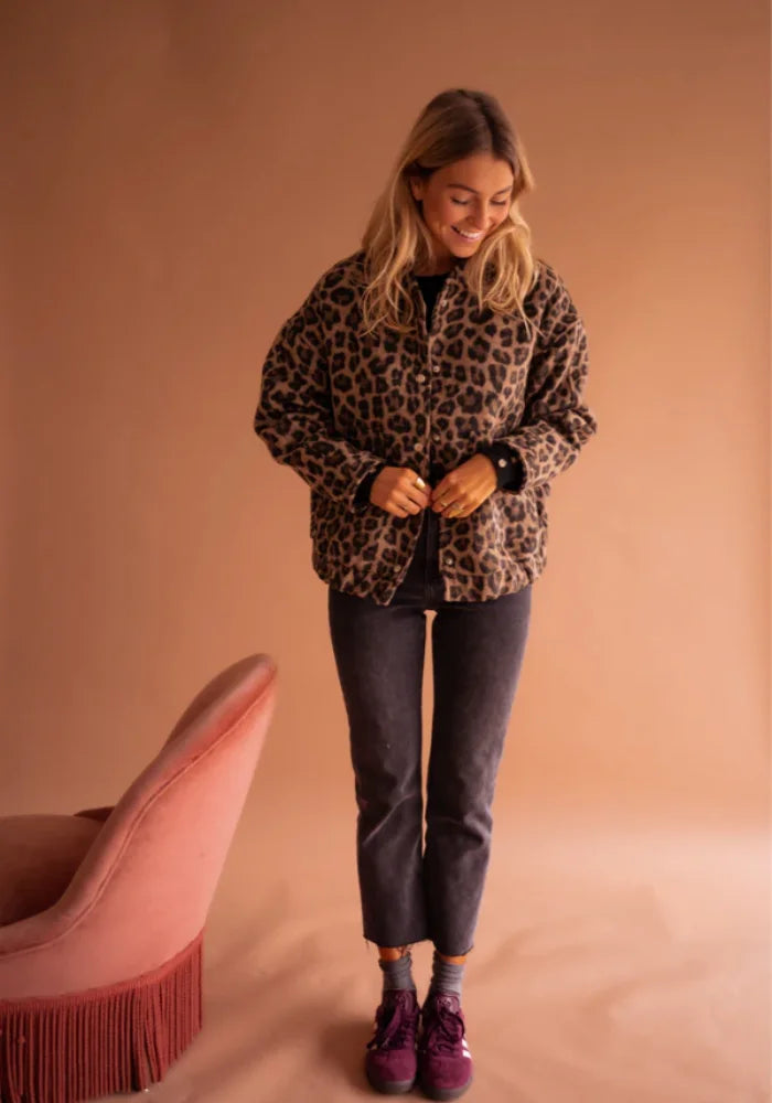 Women's leopard print button-up jacket made of soft, breathable fabric with a playful design and functional front pockets.