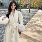 Women's long belted coat featuring soft fabric and faux fur cuffs for added warmth and style in a classic silhouette.