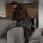 Women's long faux fur coat in soft, fluffy material with a cozy design, perfect for winter outerwear.