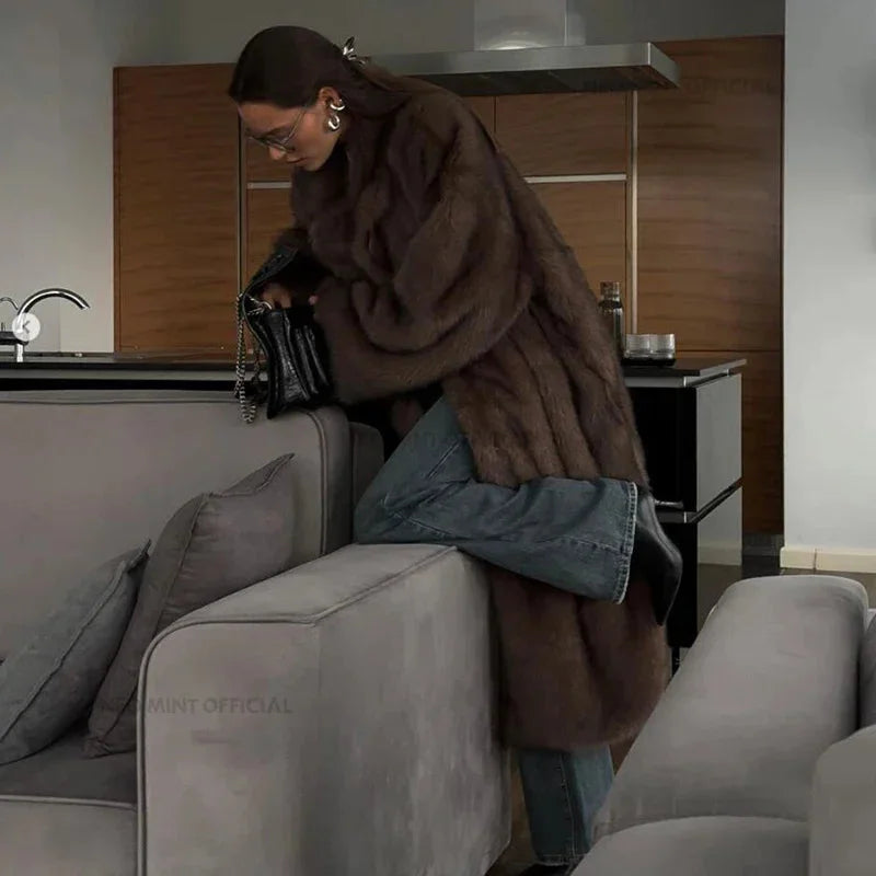 Women's long faux fur coat in soft, fluffy material with a cozy design, perfect for winter outerwear.