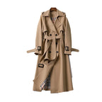 Women's long trench coat with a belted waist, lapels, and durable fabric, perfect for layering in colder weather.