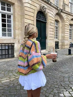 Women's multicolor knitted cardigan featuring a playful pattern, crafted from soft, cozy yarn for comfort and warmth.
