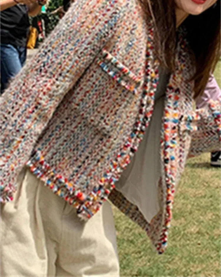 Women's multicolor tweed jacket featuring fringed edges and a textured, woven fabric for a unique layered look.